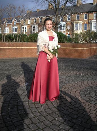 Rebeca's sister Sarah standing in the sunshine outside the registry office in a lovely red dress