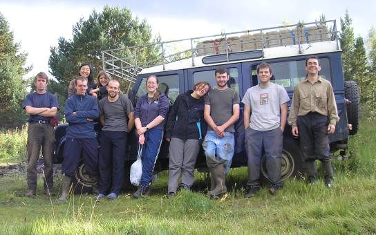 Photo of 10 of the team standing in front of the landrover, on site on the last day. Becky, Jo and Orphilie had had to go home by this point.