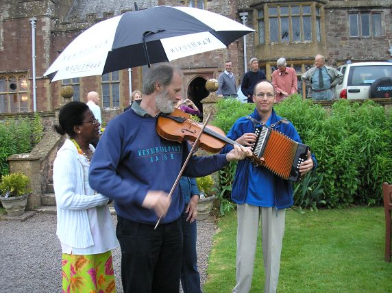Violinist and accordianist under an umbrella